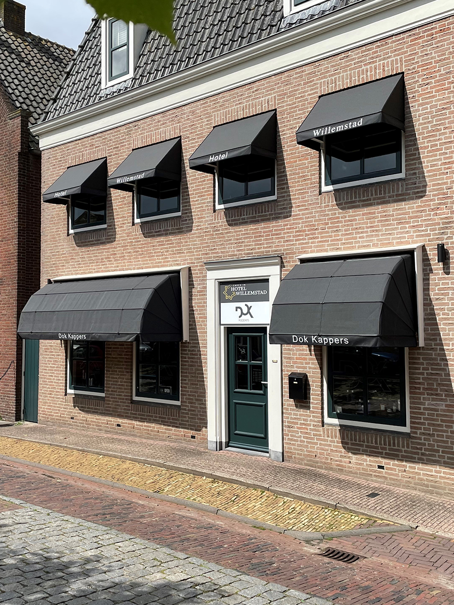 De gevel van Hotel Willemstad met zwarte markiezen aan de Voorstraat